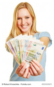 Junge blonde Frau hält Fächer mit Euro Geldscheinen in ihren Händen